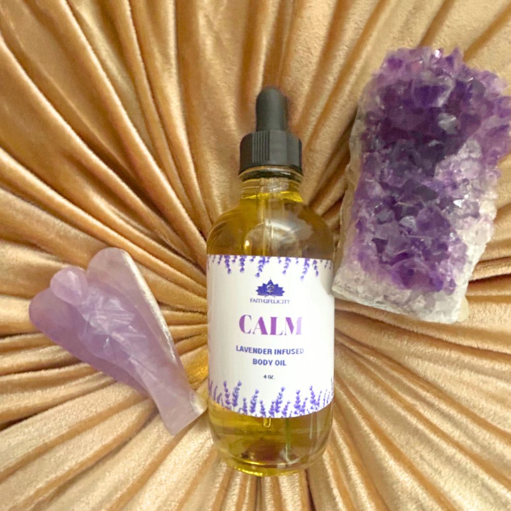 Bottle of 'Calm' lavender-infused body oil with a purple crystal and massage tool on a textured Faith2Felicity gold background